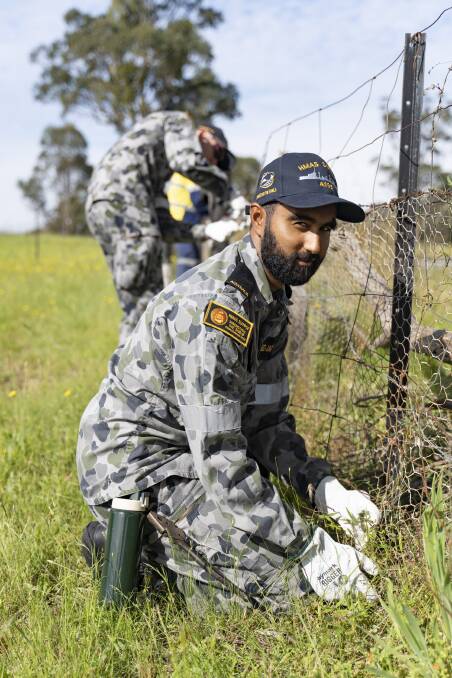 Rebuild effort: NUSHIP Supply crew member Seaman Communication Information Systems Akshay Gomez-Jackson replaces wire fence netting at a Cobargo property. Picture: ABIS Leon Dafonte Fernandez