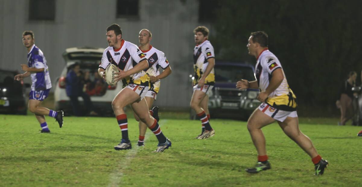 Front row: Mitch Carter shapes for a big run against the Merimbula-Pambula Bulldogs when the clubs met under lights in an Anzac tribute. 
