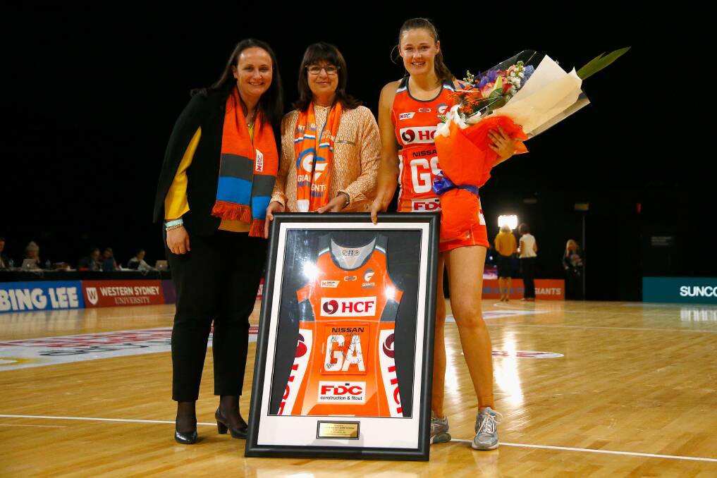 Thank you gift: Retiring star Susan Pettitt (right) is presented a plaque for her service to the Giants with the club clinching the minor premiership. Picture: AAP.