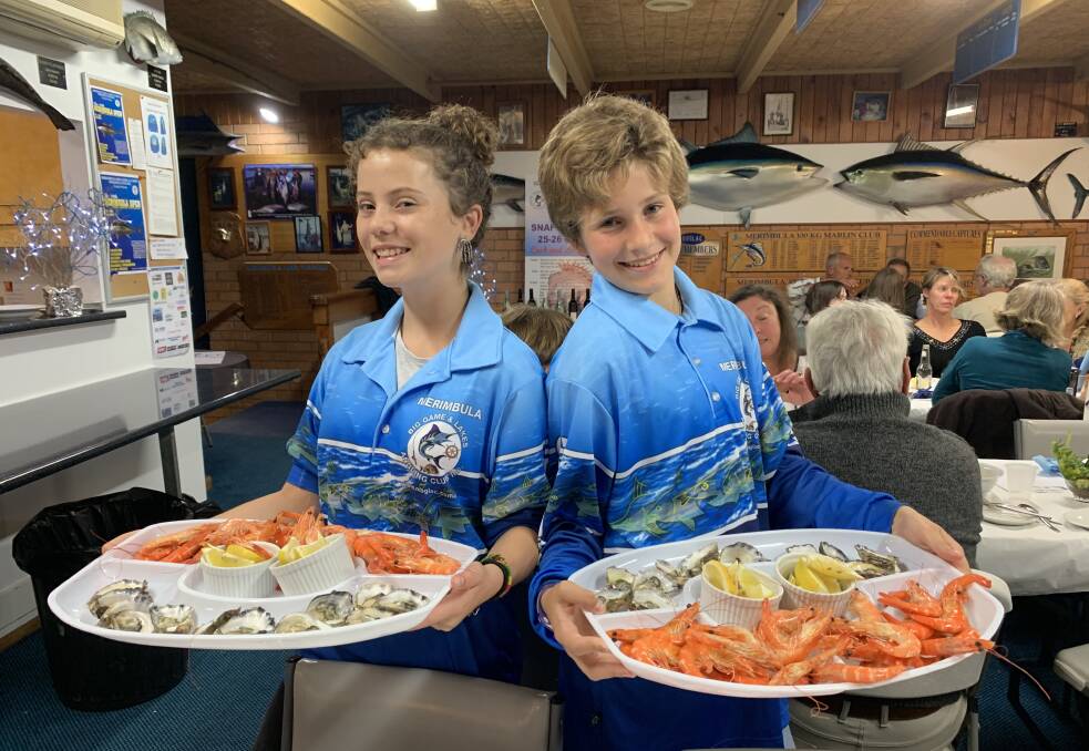 Seafood anyone?: Sinead McKay and Elli-Sky Dulhunty serving seafood platters at the Merimbula Big Game & Lakes Angling Club's annual Seafood Dinner last Saturday.