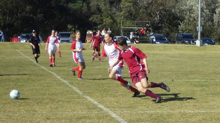 Midfield contest: A Tathra junior swivels to contend the ball with a Bega Devils player during a contest last season with the United club at home last Sunday. 