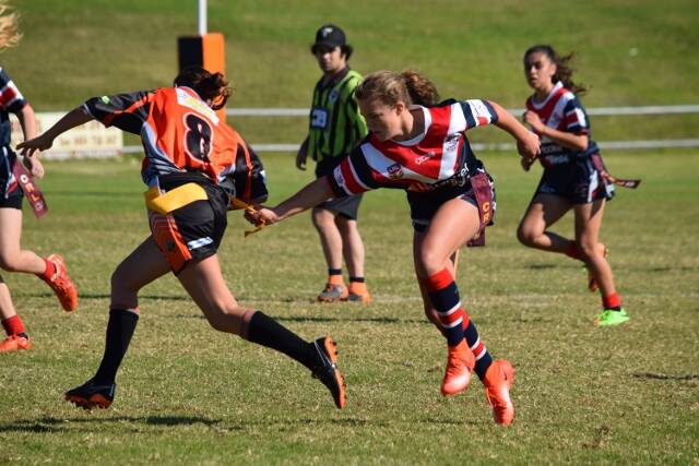 Got you: A Rooster gets to grips with her opponents tag during a recent clash as the minor league clubs head into finals time. Picture: Wendy Deighton. 