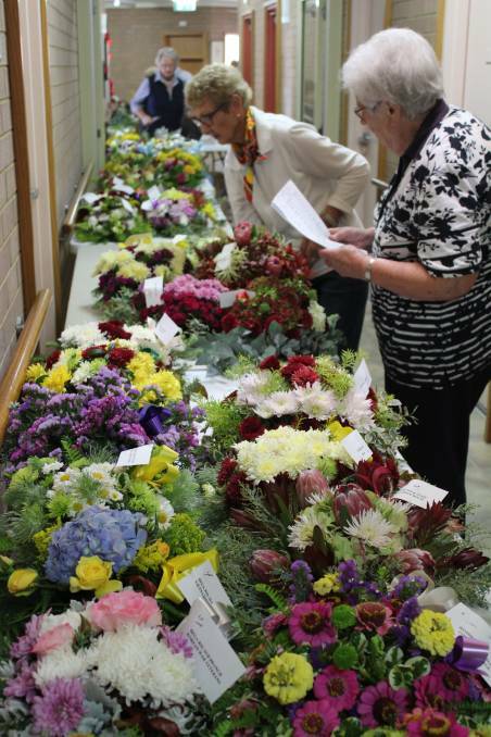 Volunteers inspect the wreaths ahead of Anzac day services in 2019. 