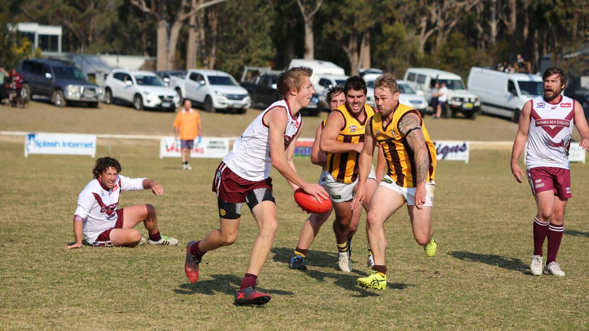Send it: A Sea Eagle looks to get a kick away as three hungry Panthers move in during Saturday's elimination final. 