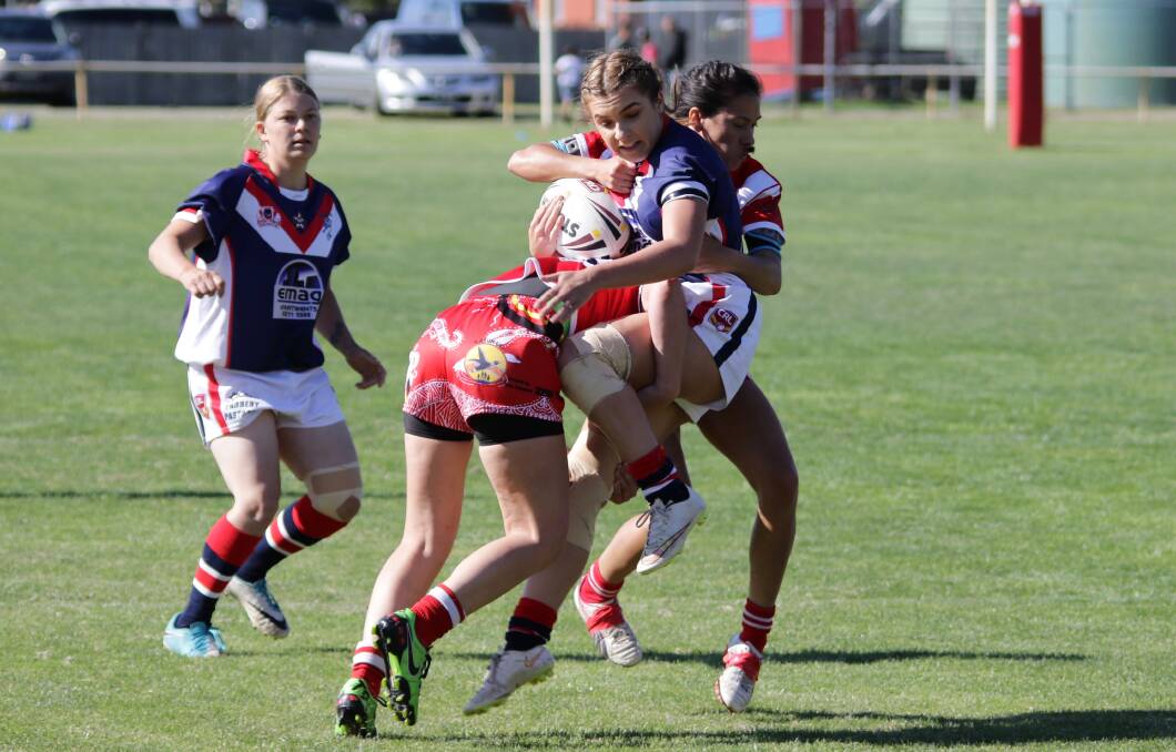 Strong hit: Alex Spivey is wrapped up by two Narooma defenders during Bega's close loss to the Devils on Saturday. Picture: Peter Sheales. 