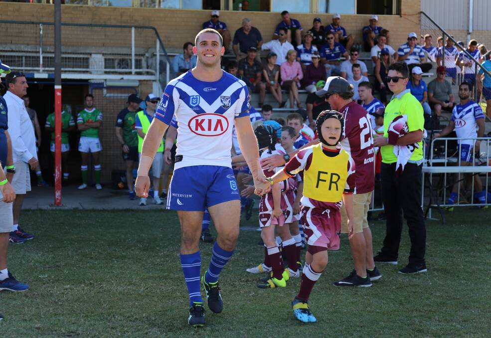 Adam Elliott walks on to the Bega Rec Ground with one of the Tathra Sea Eagles under 8s ahead of a Welcome to Country ceremony. 