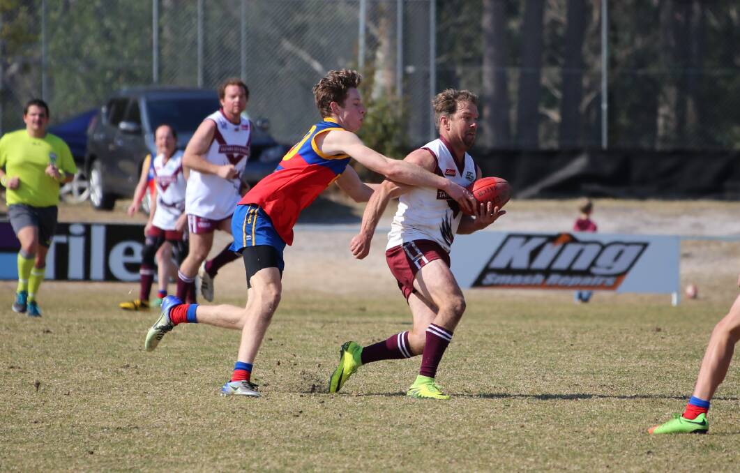 Going through: A Sea Eagle looks to escape his Narooma opponent during the minor semi-final recently. Tathra have advanced to the grand final. 