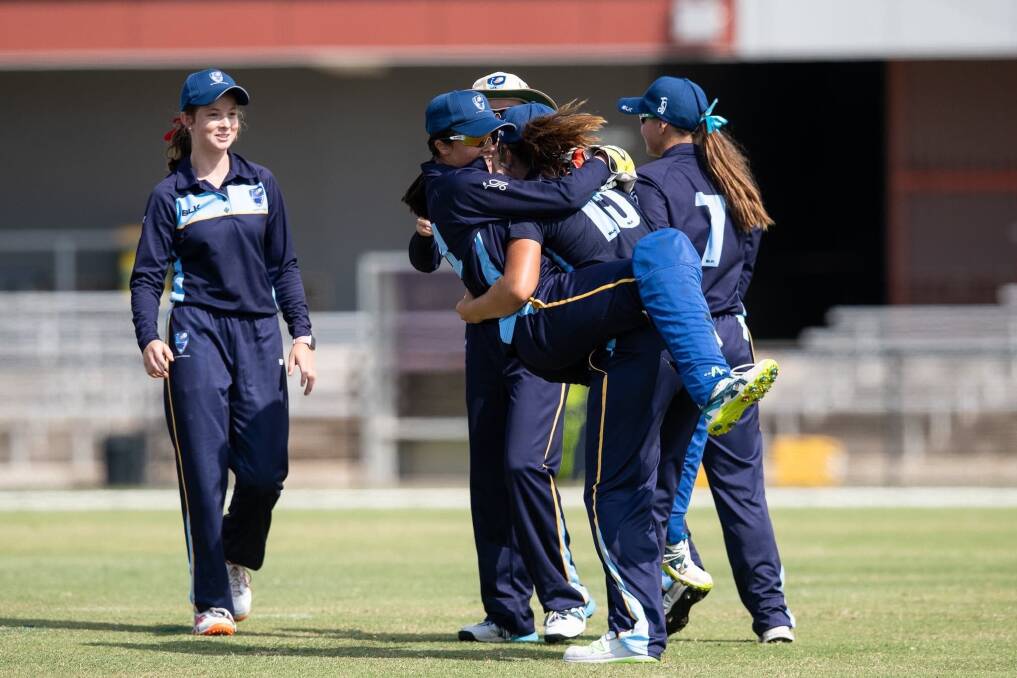 Standout: Jessie Mudaliar (15) gets a hug from team-mates after clearing out the last pair of NSW Metro batters in the final. 