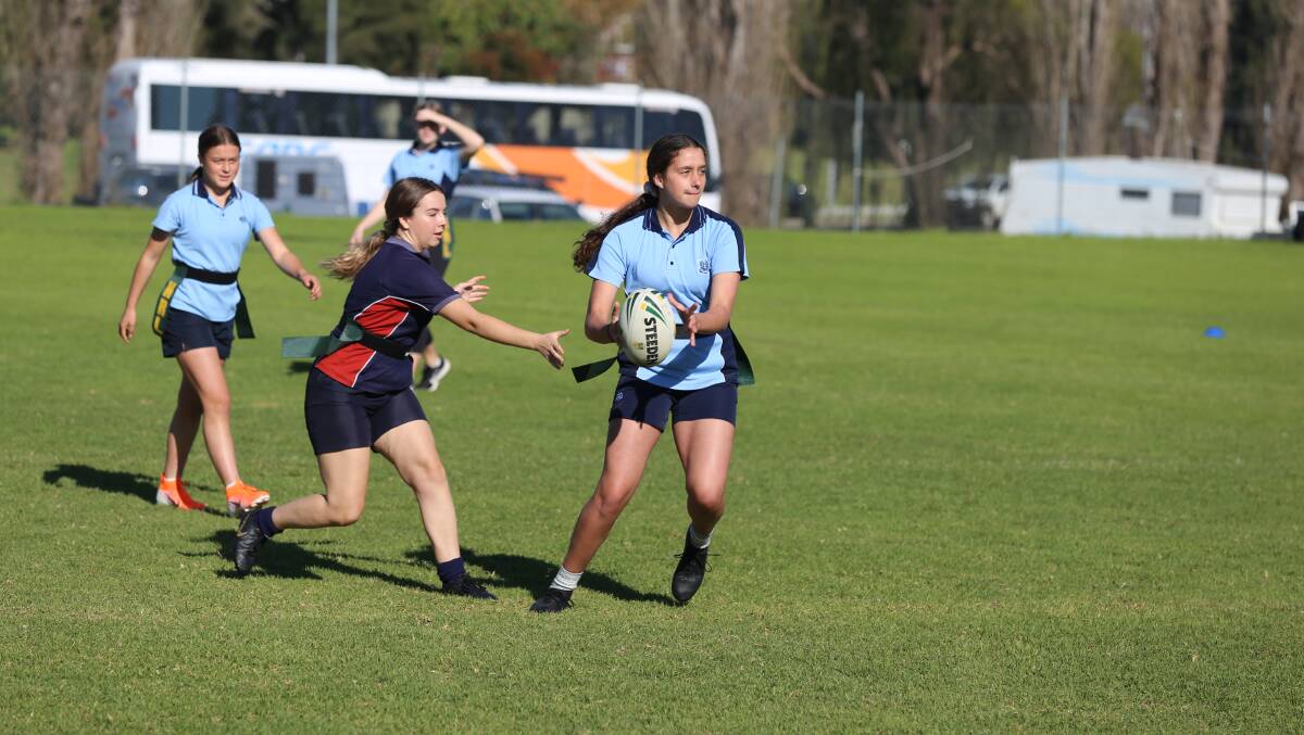 A Bega High student looks for an offload before getting tagged by her Lumen Christi opponent during the Kezie Apps Shield on Thursday. 