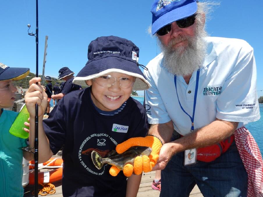 Free lessons: Young Jae Hun, with a Fishcare Volunteer, learns about fishing techniques at the club's jetty in Spencer Park, Merimbula.