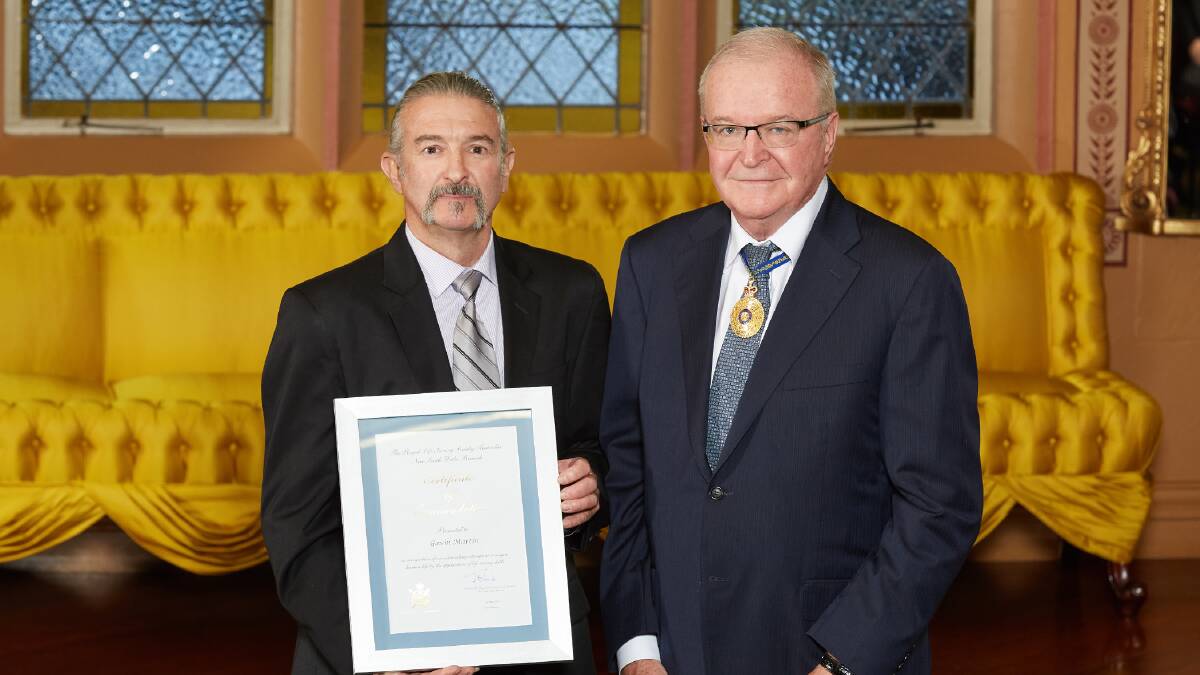 AWARDED: Bega's Gavin Martin receives his Royal Life Saving NSW award from Lieutenant Governor of NSW Thomas Bathurst. Picture: Rob Tuckwell Photography