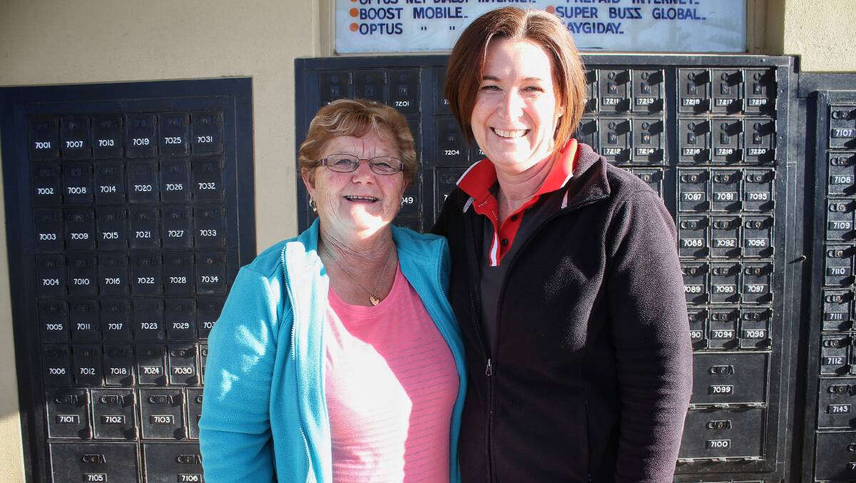 TOP OF THE WORLD: Tathra Post Office's Deb Alker (right) with regular customer Rhonda McGregor on Thursday. Picture: Alasdair McDonald