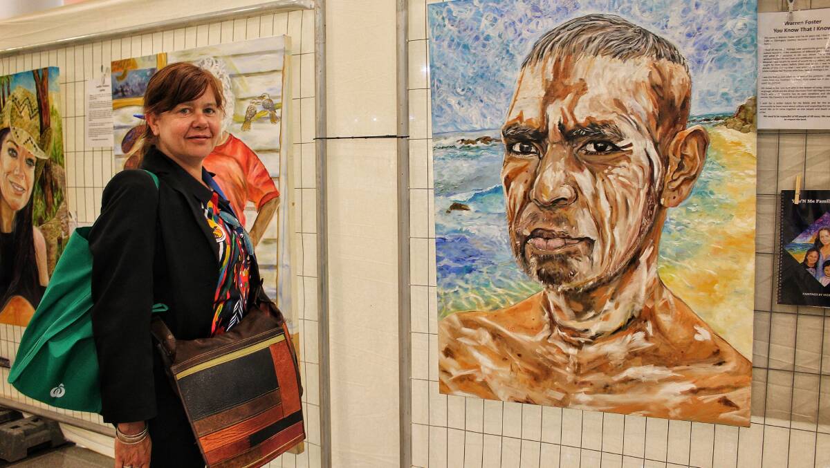 FACES: Jo Norton-Baker admires Vickie McCredie's portrait of Wallaga Lake's Warren Foster Sr ahead of the festival. Picture: Alasdair McDonald