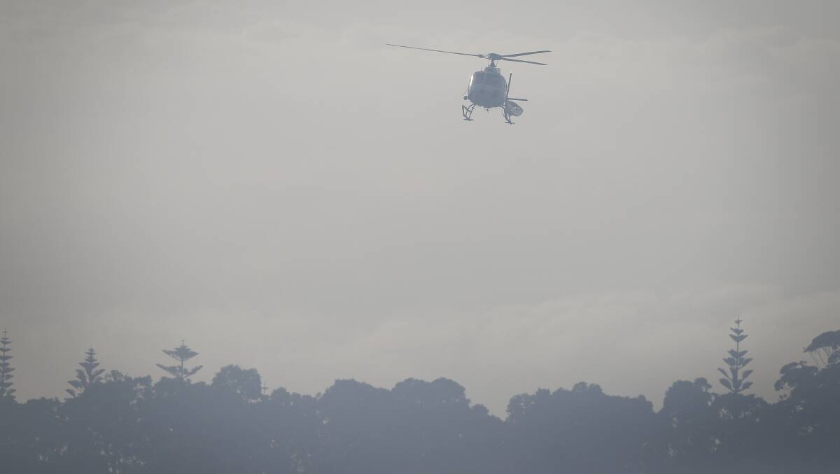 A helicopter over Tathra during the recent bushfire tragedy Picture: Alex Ellinghausen