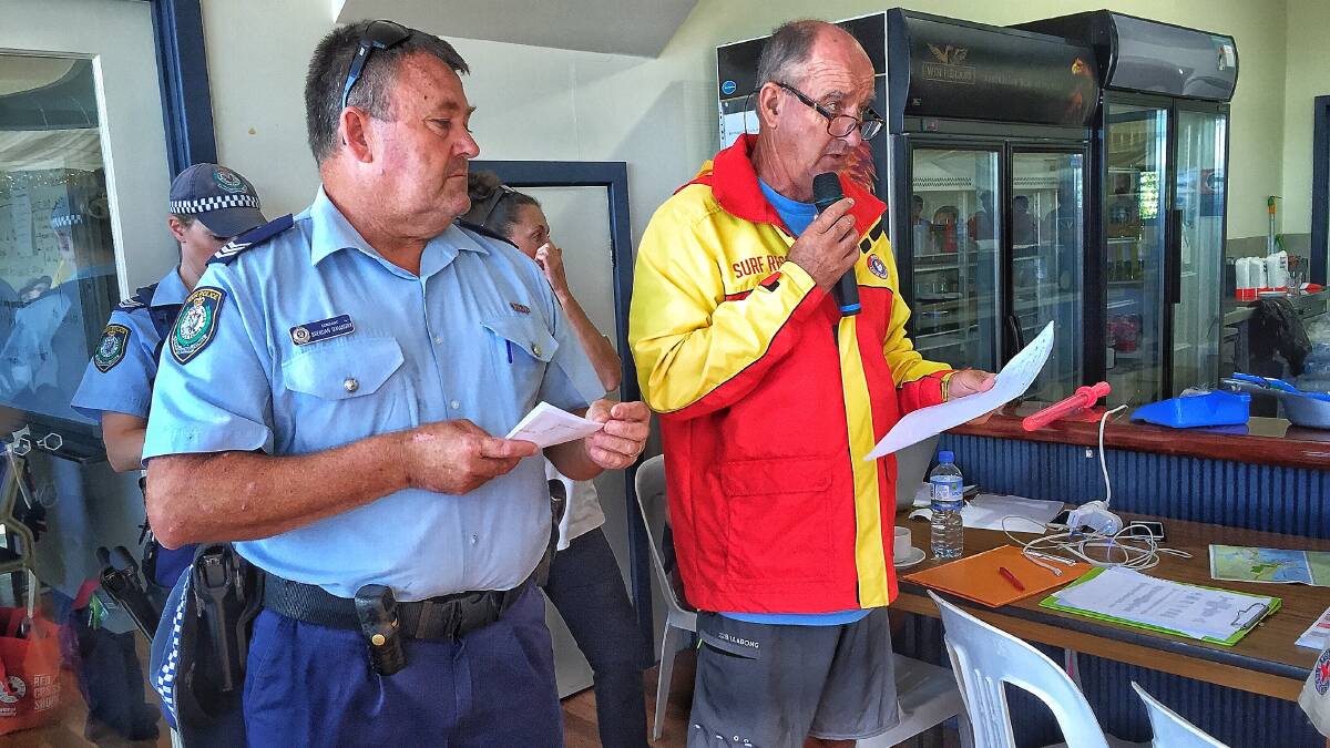 NSW Police sergeant Brendan O'Mahony and Bermagui Surf Club's Neil Rutherford provide evacuees with information on Monday morning. Photo: Alasdair McDonald 