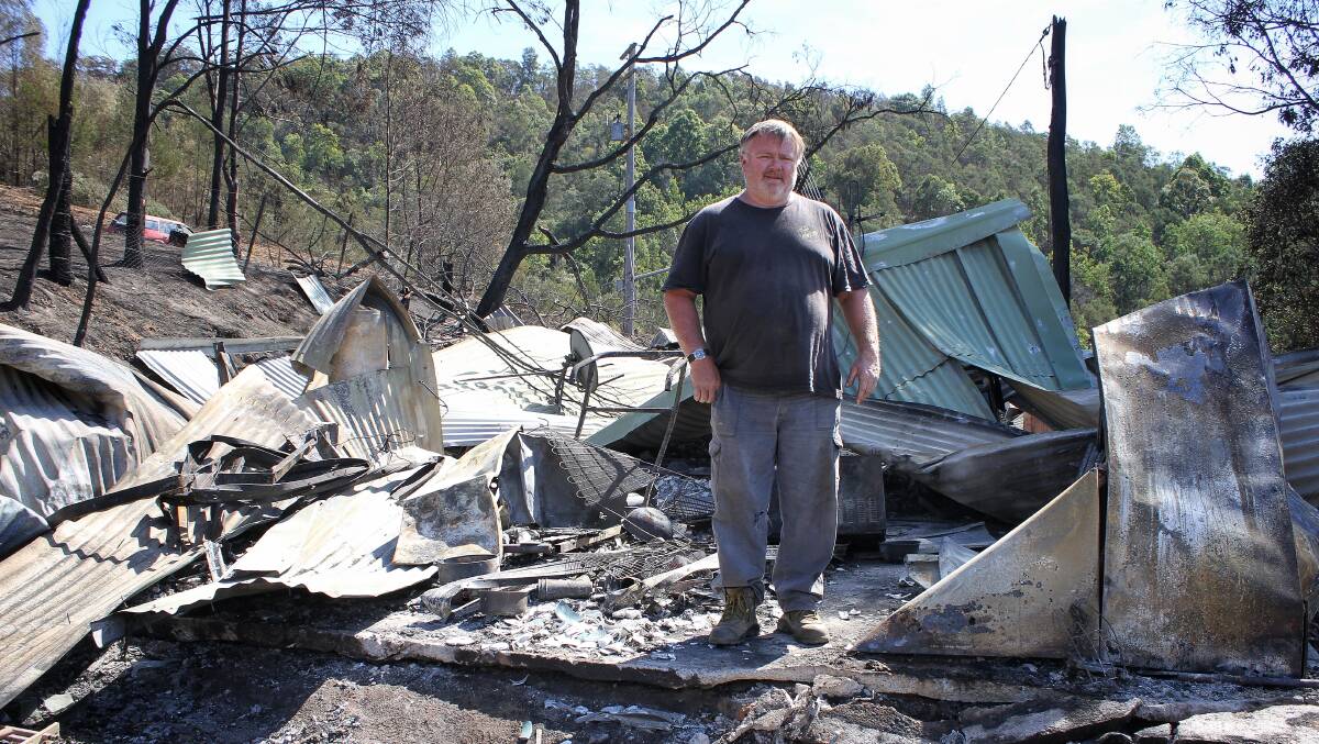 DEVASTATION: Glenn Scrymgeour surveys the remnants of his family cabin in the wake of Cobargo's September 7 bushfire. Photo: Alasdair McDonald