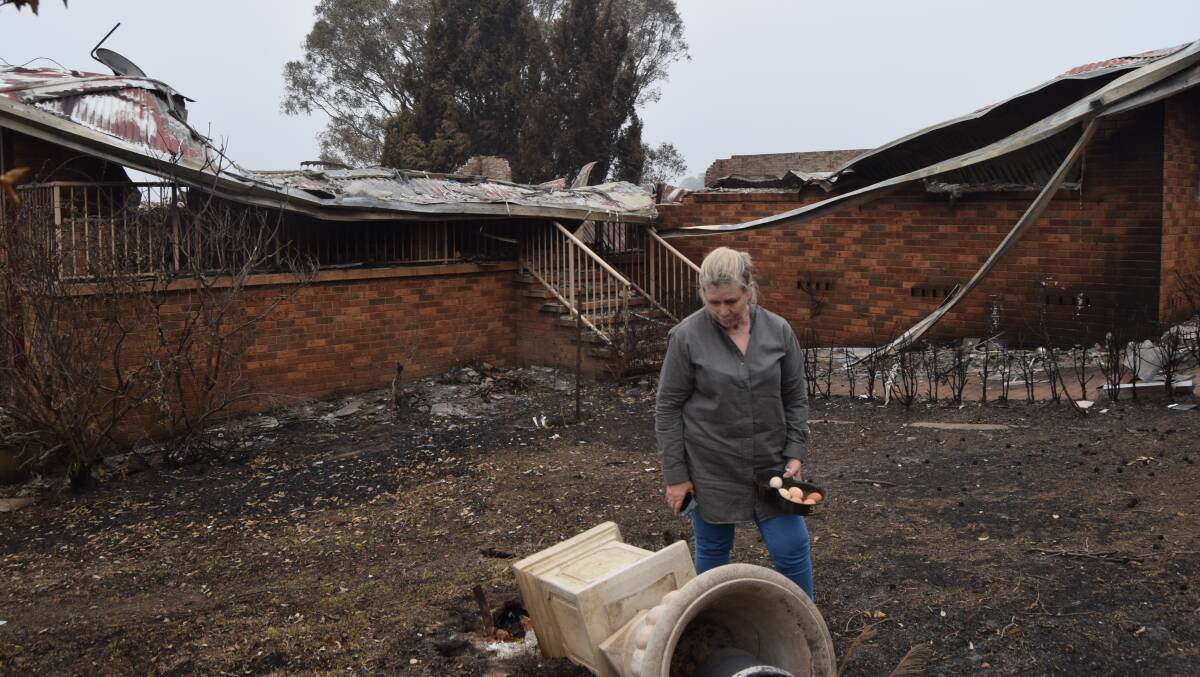 Graeme Freedman's wife Robyn holds the last of her chicken eggs after the couple's home was destroyed by a fire cloud on New Years' Eve. Picture: Graeme Freedman