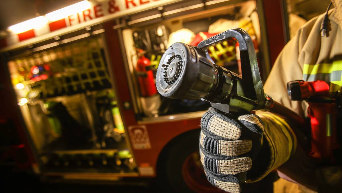 A fire fighter holding a first aid hose. Picture: Adam McLean
