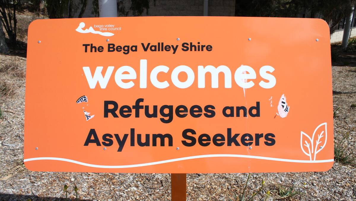Bega Valley resident Ian Campbell removed stickers from the recently unveiled refugee welcome sign outside the Bega library.