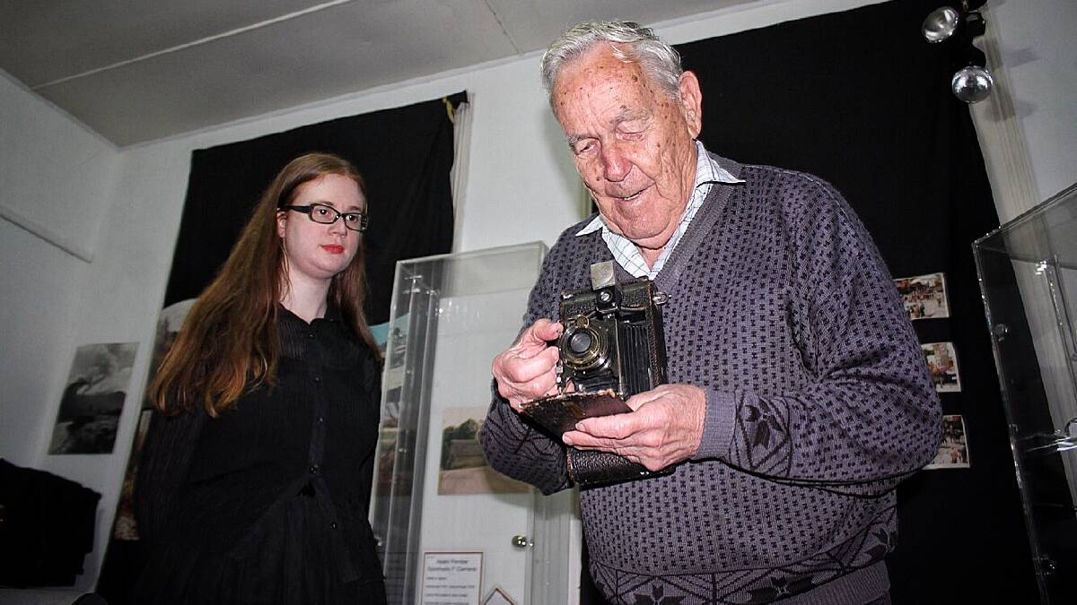 Historical society president Peter Rogers holds one of the exhibition's folding cameras from the 1930s as museum volunteer Loretta Ashby looks on. Picture: Alasdair McDonald