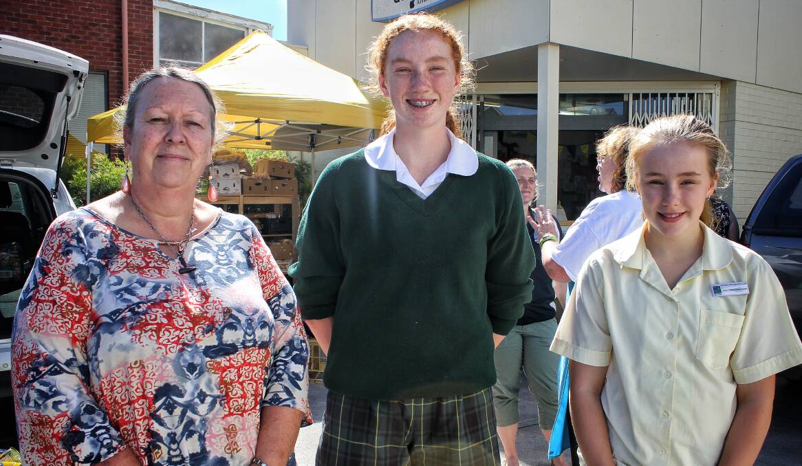 Glennda Heino of Quaama with Sapphire Coast Anglican College students Zali Smith and Lydia Weber at the Sapphire Community Pantry on Thursday. Picture: Alasdair McDonald