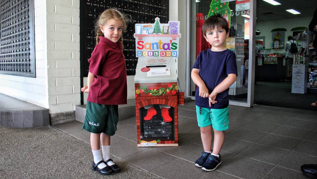 FESTIVE SEASON: Numbugga's Lilian Armstrong and her brother Lucas next to the Bega Post Office's Santa's Mail Box on Tuesday. Picture: Alasdair McDonald