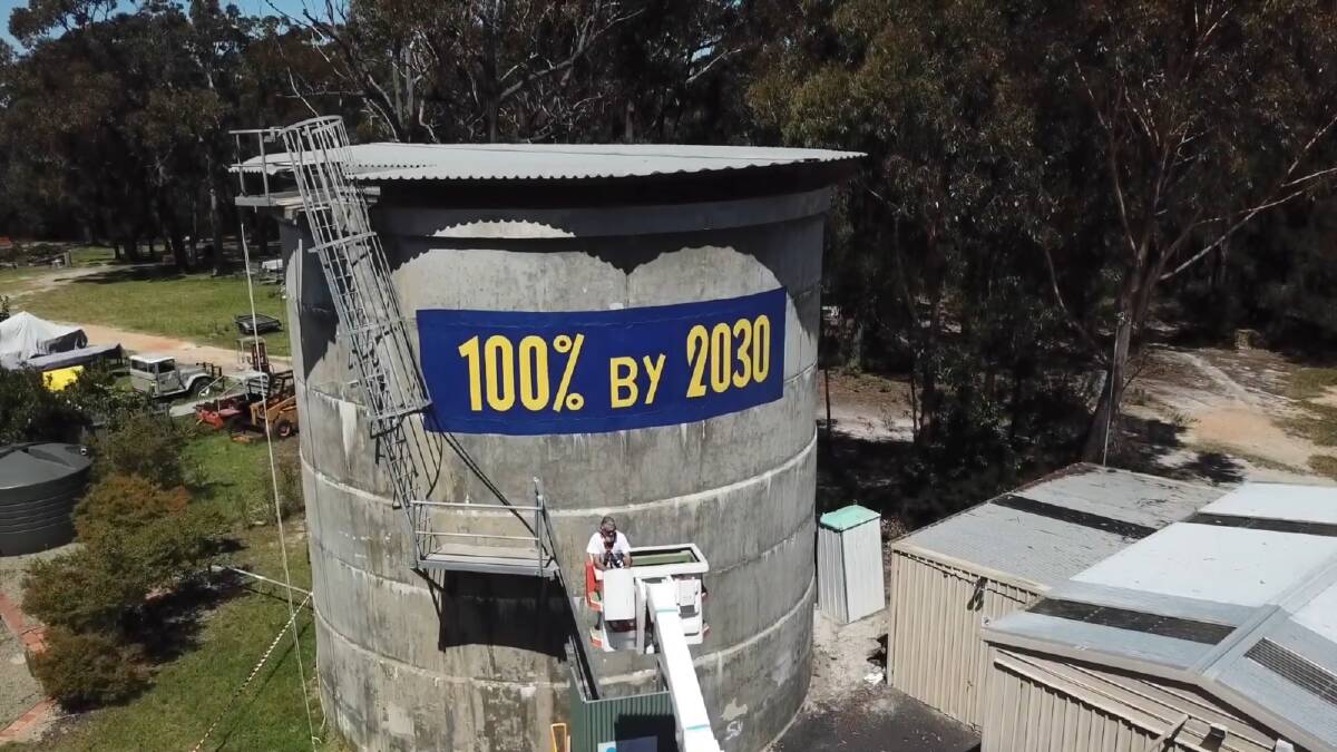 Tathra's newly adopted clean energy target was painted above the town on Saturday by Gavin Martin who donated his time to the cause. The paint was donated by Bega's Inspiration Paints. Picture: Alasdair McDonald