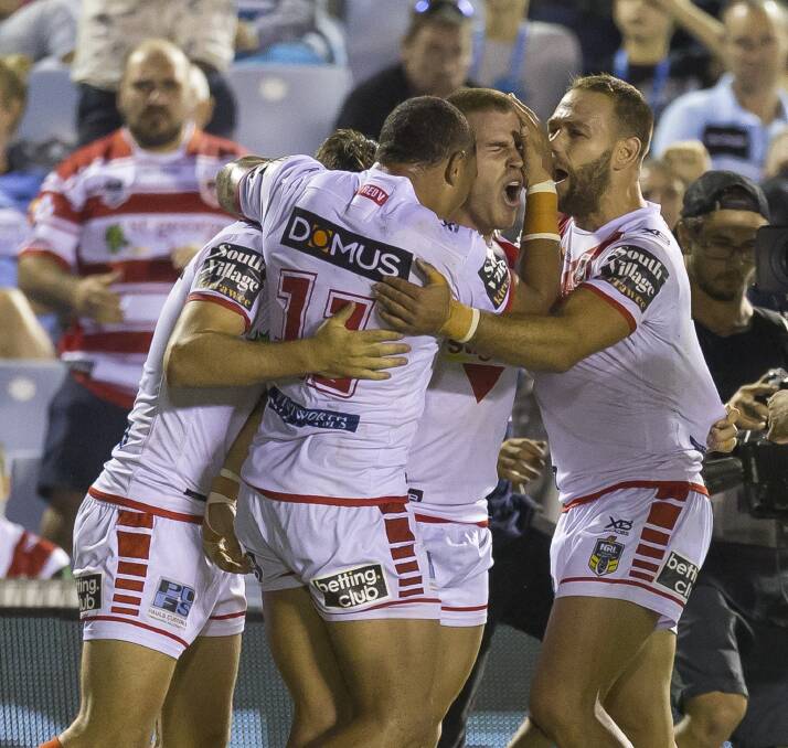 HOW GOOD: Euan Aitken is congratulated by team-mates after a cracking try against his opposite number in Greg Inglis last week. Picture: AAP