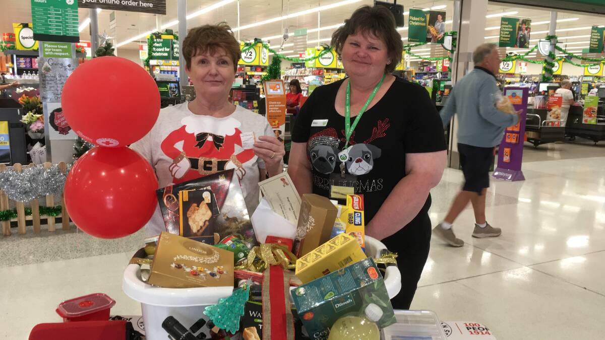 Jan and Alison from Woolies Tura Beach draw the Red Cross raffle.