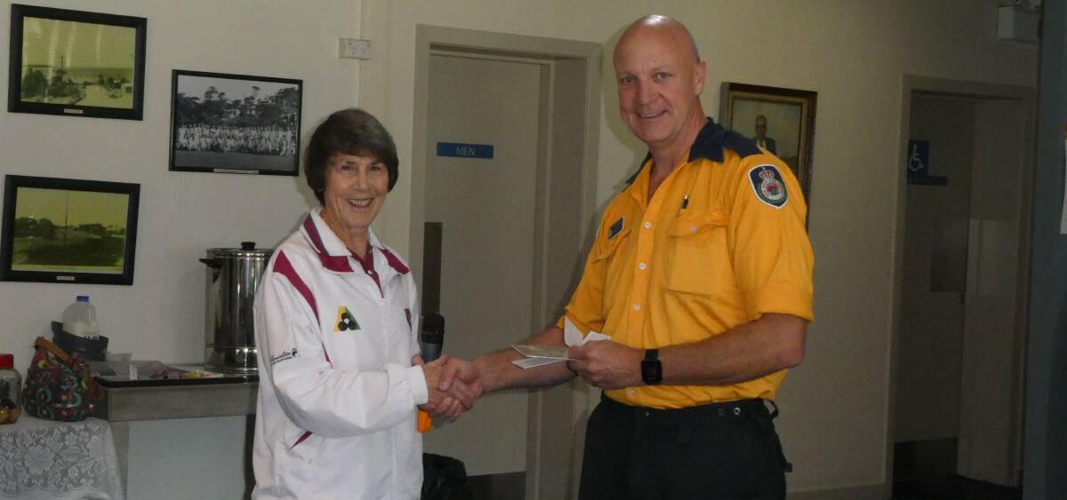RFS donation: Tathra Beach Women's Bowling Club Vice-President Pat McRae presents a cheque for $1500 to Rural Fire Service District Officer Gary Cooper.