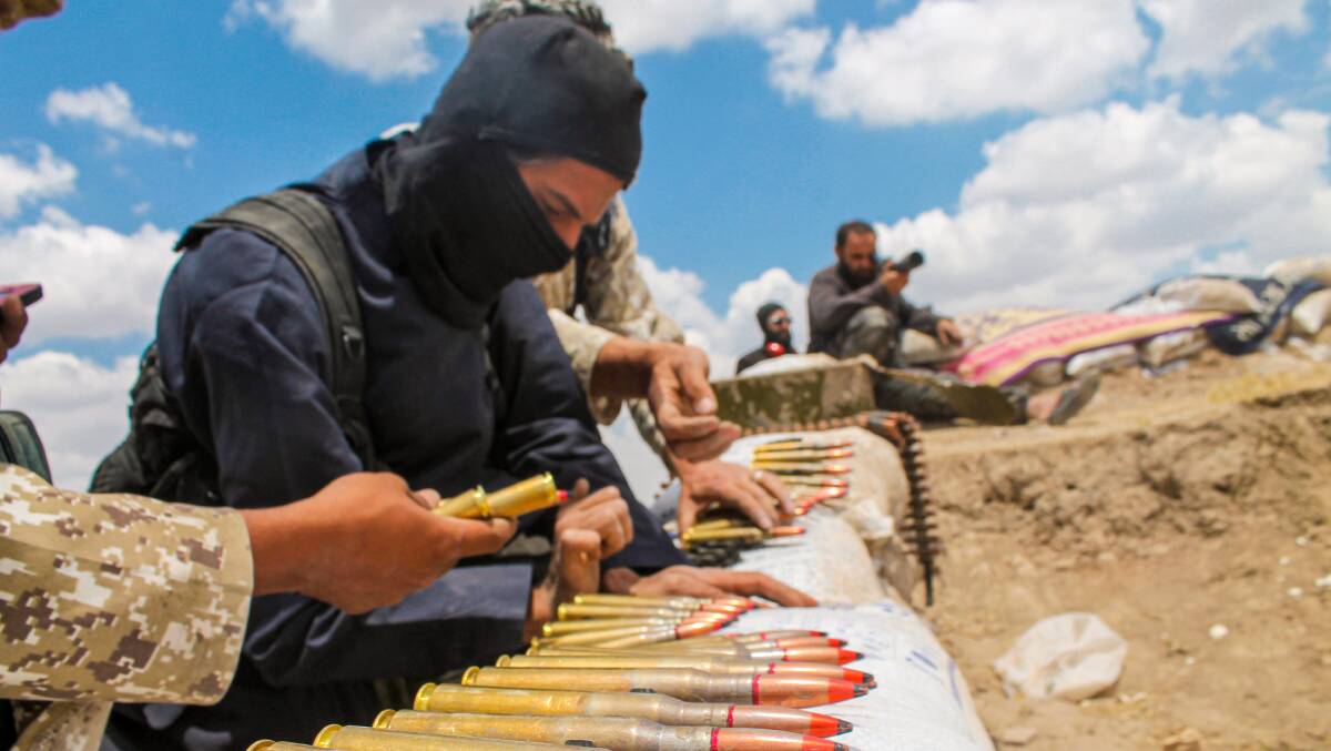 A soldier in an ISIS uniform prepares ammunition in Syria. Picture Shutterstock