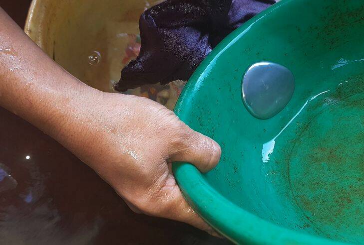 Sifaiyah swirls a bucket with mercury that has attracted the gold to it.  Mercury is being used to extract gold from rock. A study has revealed that high levels of mercury have been found in women of child bearing age in Sekotong village, Lombok, Indonesia. 21st September, 2017. Photo:Amilia Rosa                                 