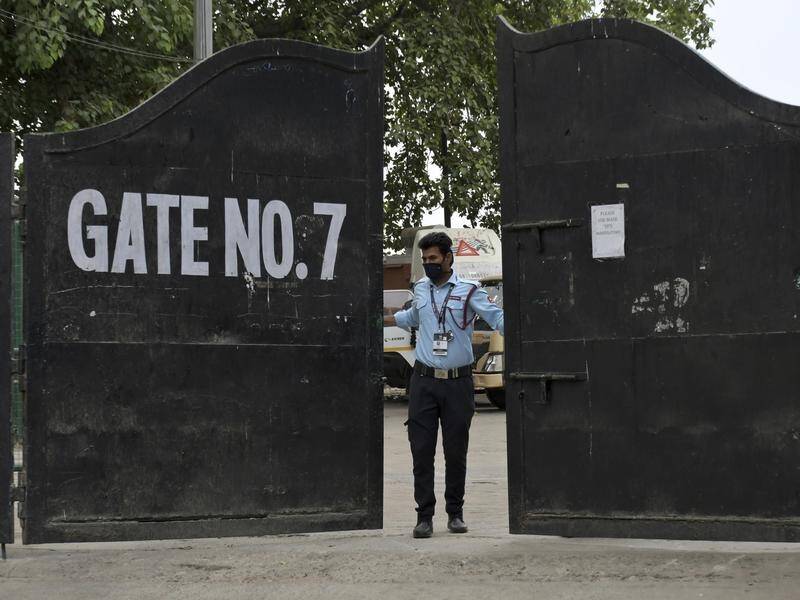 A guard closes a gate at an Indian Premier League venue after the tournament was suspended.