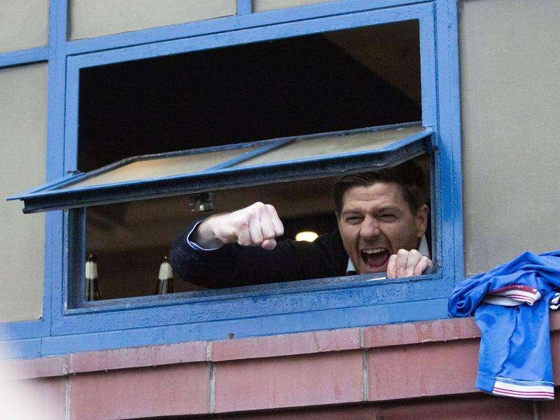 Rangers manager Steven Gerrard looks out of the window at Ibrox on Saturday to cheer with fans.