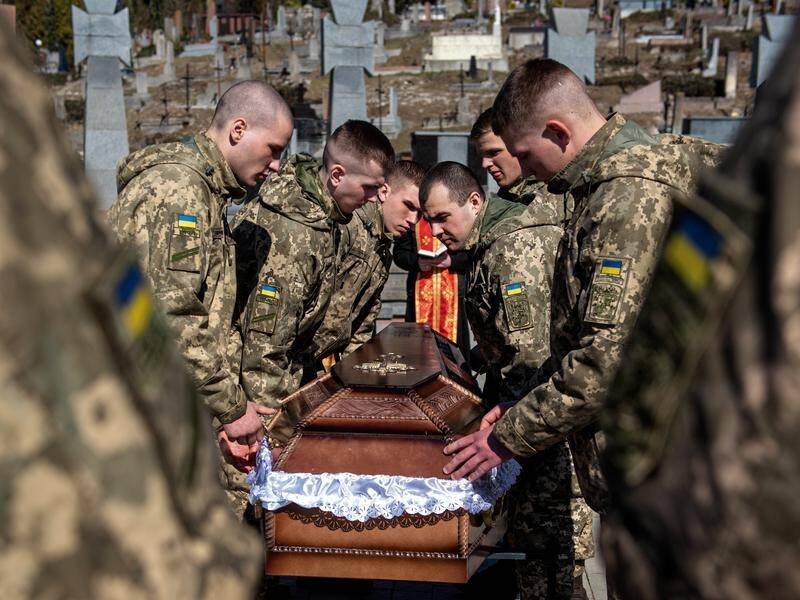 Ukrainian soldiers carry the coffin of a comrade at the Lyczakowski cemetery in Lviv, Ukraine.