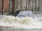 A car drives through floodwaters in Newry Town, County Down, Northern Ireland (AP PHOTO)