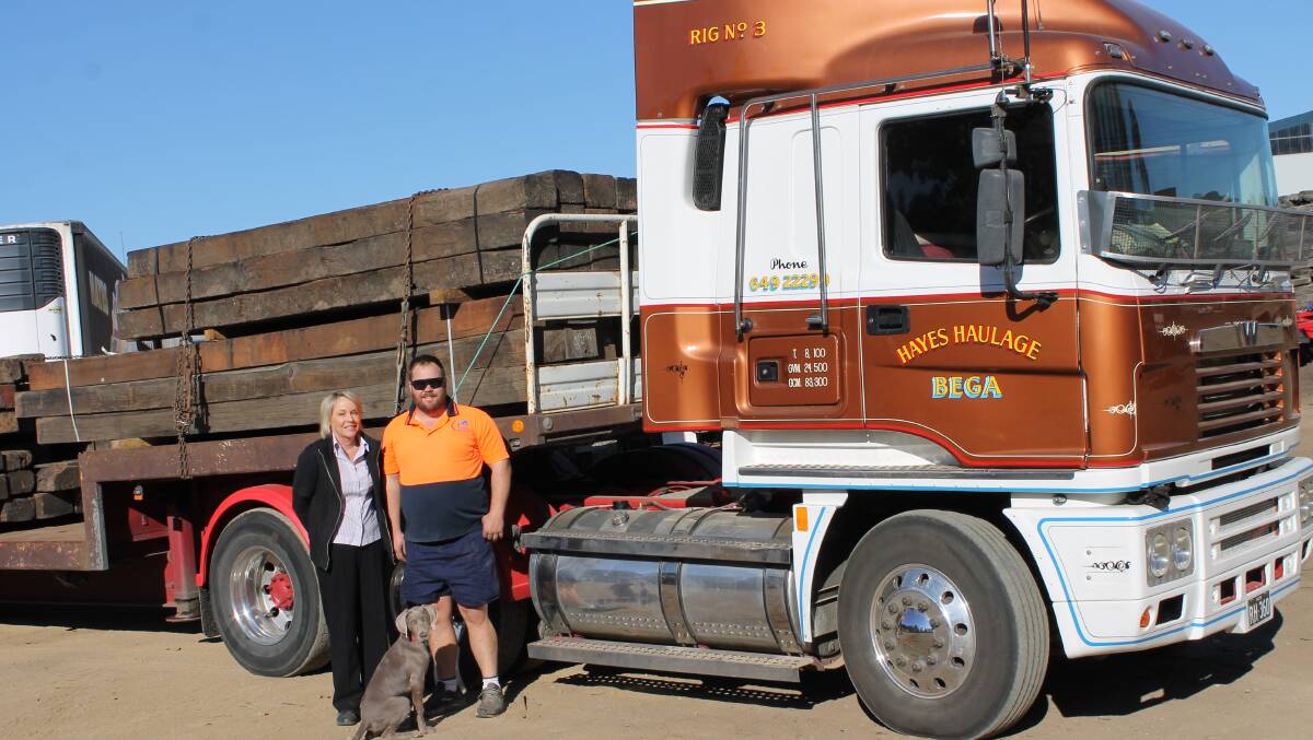 Ricky Hayes, Tom Hayes - and Loki - from Hayes Haulage prepare a load of timber rail sleepers for transport at their North Bega depot.