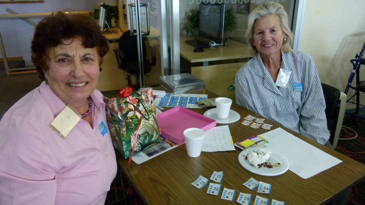 Lucy and Joan take a well-earned rest and check their tickets after manning one of the busy entry tables 
