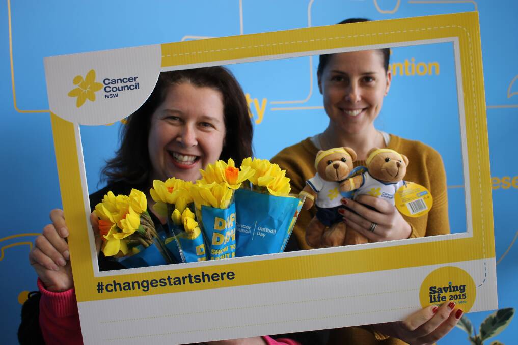 Showing off some of the merchandise available of Daffodil Day in the special frame made for the day are Bega Cancer Council’s community program coordinator Jennifer Mozina and community relations coordinator Sarah Flynn. 