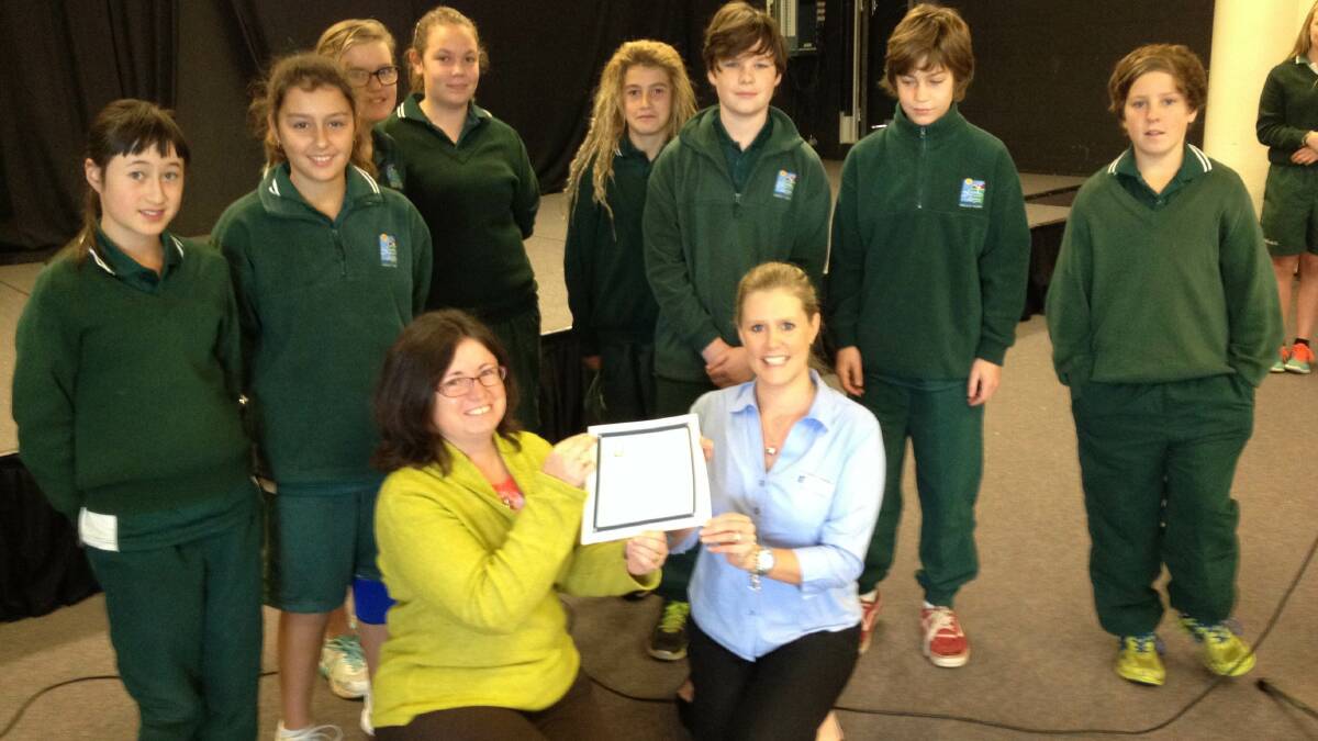 Year 7 maths students at Sapphire Coast Anglican College and their teacher Julie  Slater are thanked by CCASE secretary Kylie Ryan (front, right) for their donation.