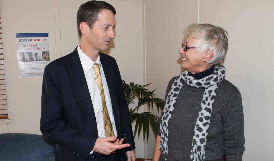 NSW Minister for Fair Trading Matthew Mason-Cox presents Anglicare's Wendy Hunter with a funding boost for the service's no-interest loan scheme.