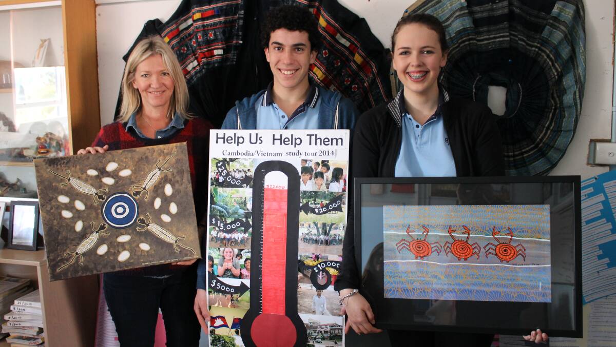 Bega High teacher Cheryl Atkinson, and students Rhys Davies and Annie Fitzer show off the two paintings they are raffling for organisations in Cambodia and Vietnam.