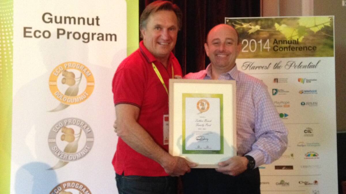 Tathra Beach Family Park co-owner Frankie J Holden is presented with a Gold Gumnut at the Caravan and Camping Industry Association (CCIA) state conference by CCIA NSW president Theo Whitmont.