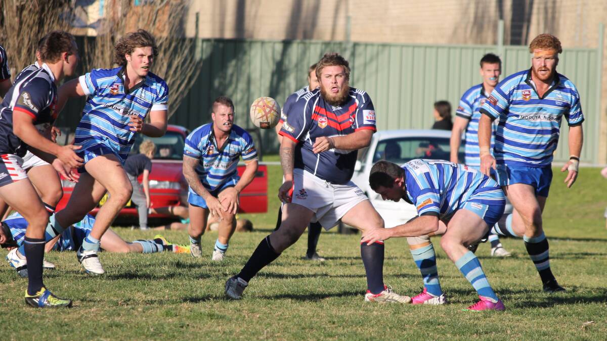 • Rooster Billy Hudson offloads in the first half against the Moruya Sharks on Sunday. 