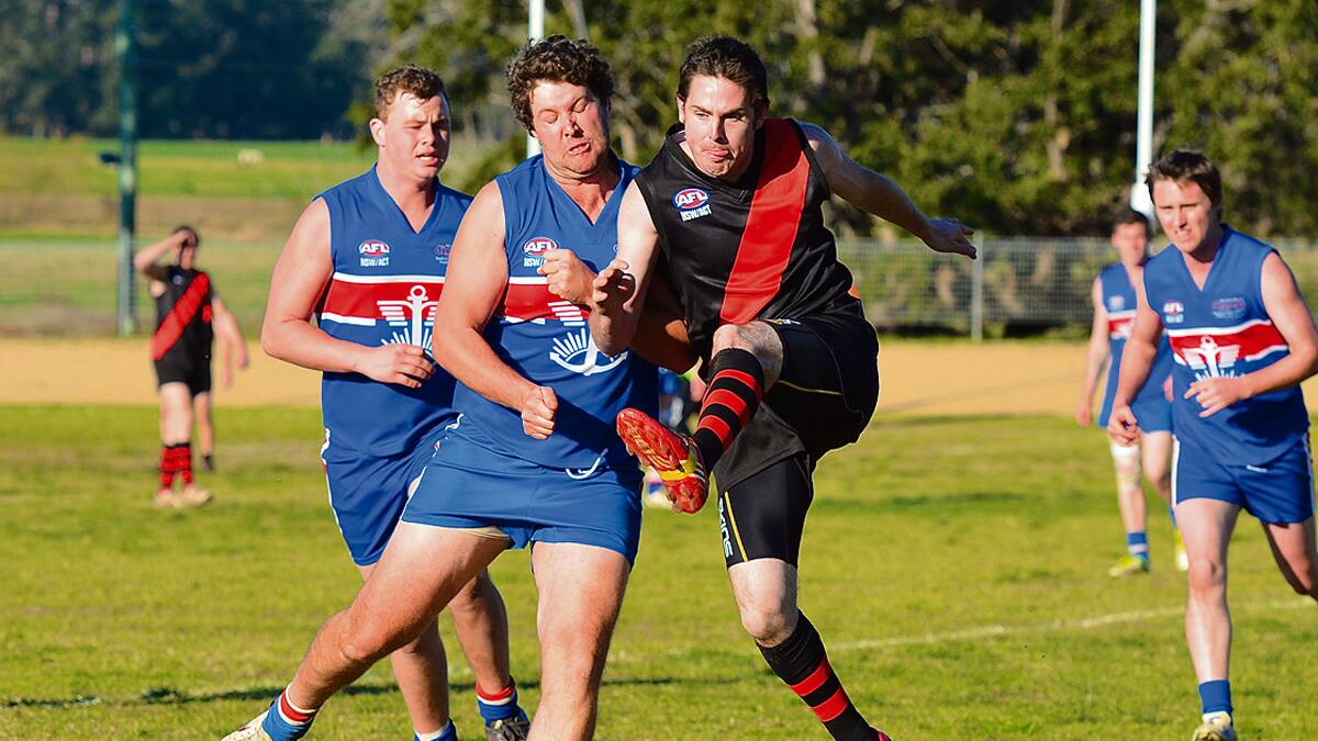 • Bomber Todd Harnett offloads a kick against the Merimbula Diggers last year.  Three junior Bombers have been selected for representative training camps. 