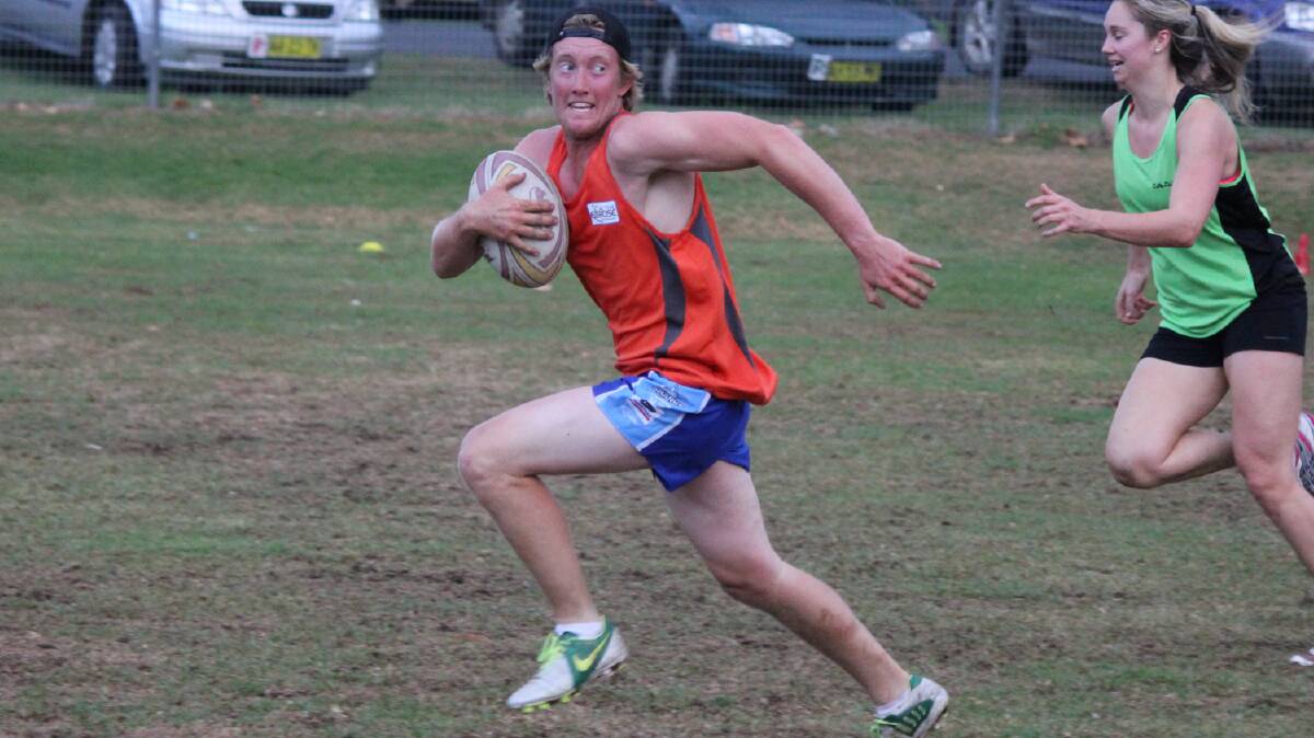 • AEC player Craig Matthews breaks the Outta Nick defensive line and runs for a try during the touch football grand final on Friday. 