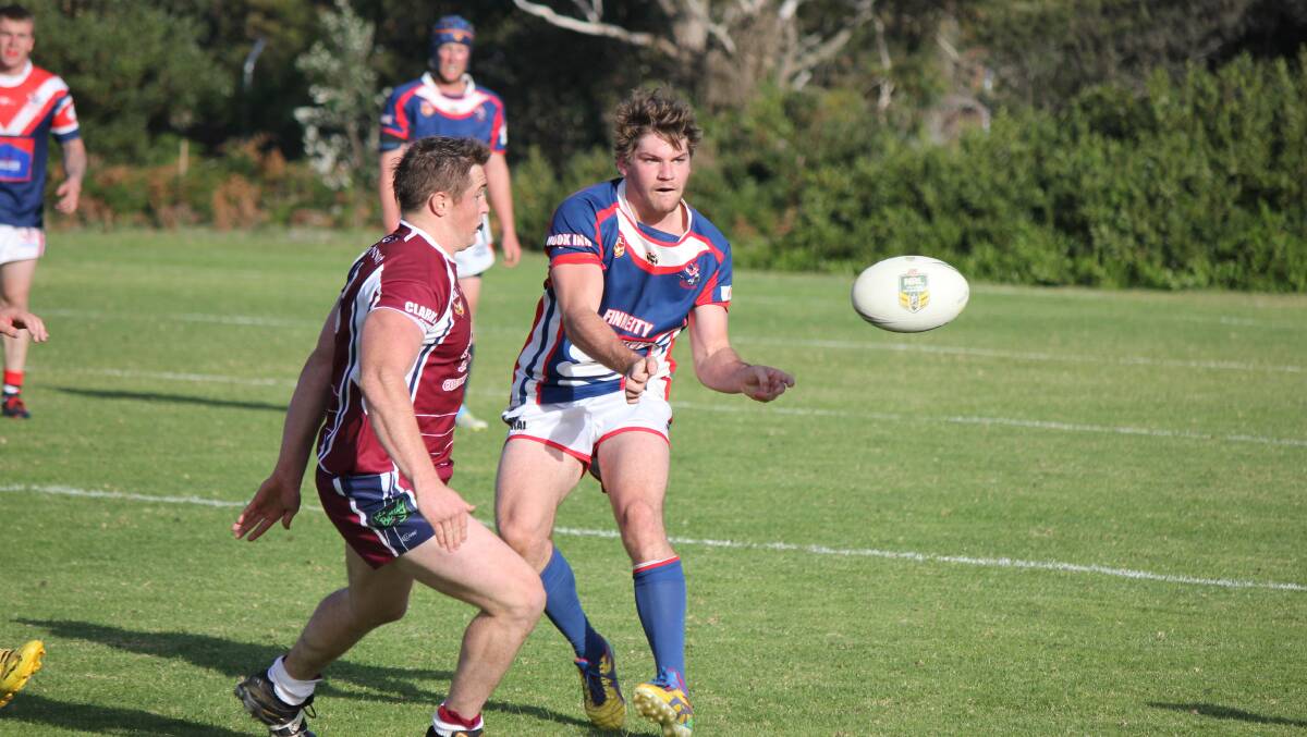 BEGA: Bega Rooster Scott Fuller offloads just in time before taking a heavy tackle from the Tathra Sea Eagles defence on Sunday. 