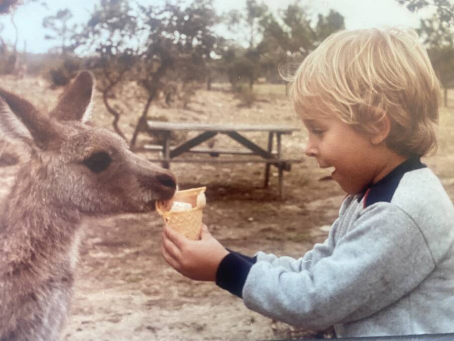 Chad as a boy makes a furry friend. Picture: Supplied
