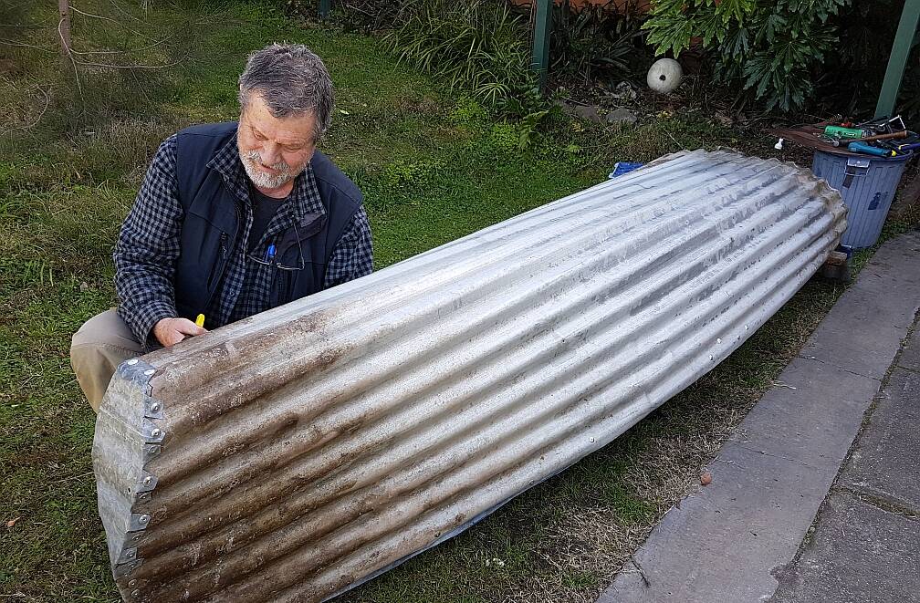 MASTERPIECE: John Blay puts the finishing touches on his striking piece Tin Canoe. The piece is on exhibit at Sculpture by the Sea in Bondi.