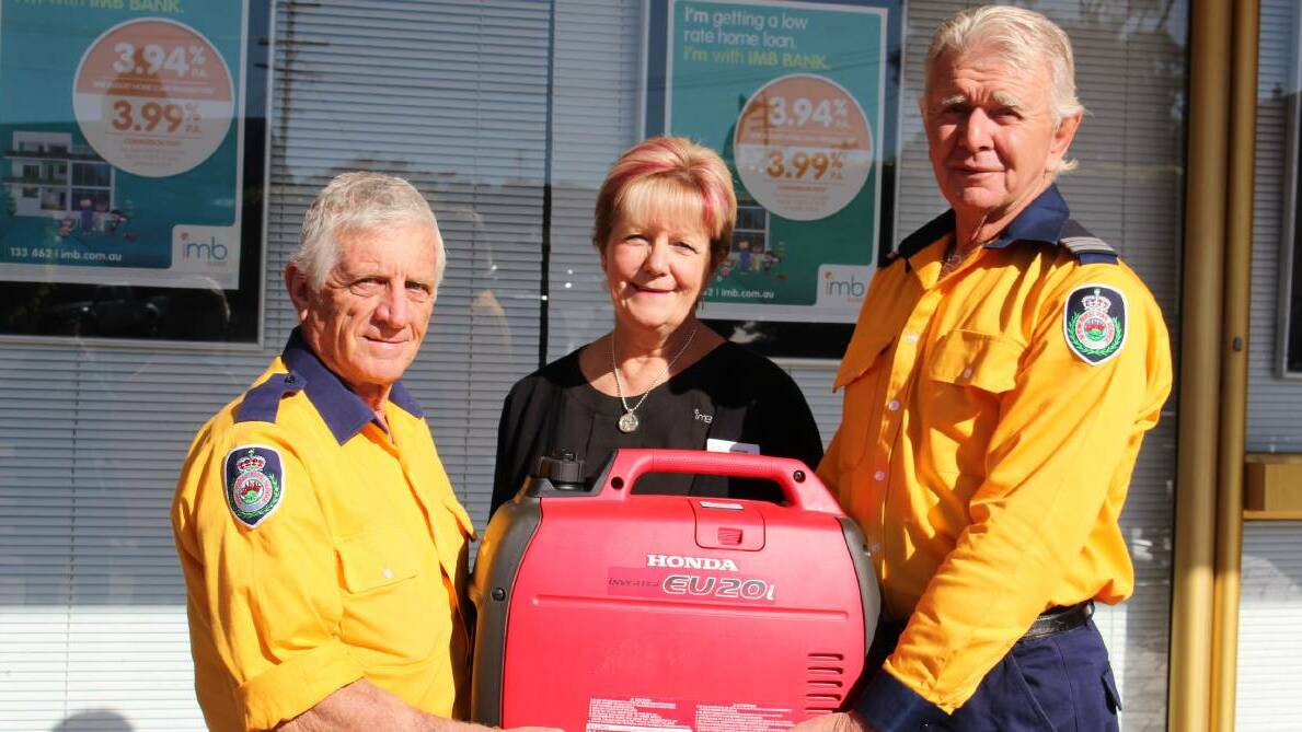 Wolumla Rural Fire Service volunteers Jim Eberbach and John Wilson show their appreciation to IMB Merimbula for the electricity generator they purchased last year thanks to a grant from the IMB Bank. 